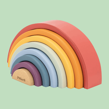 Colorful wooden rainbow stacking toy with eight curved arches in red, orange, yellow, cream, light blue, blue, purple, and dark gray, arranged from largest to smallest on a light green background.