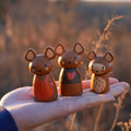 Three wooden mouse figurines from the Penny Windmill Character Play Set Wooden Toy displayed on a hand, showing detailed painted features.
